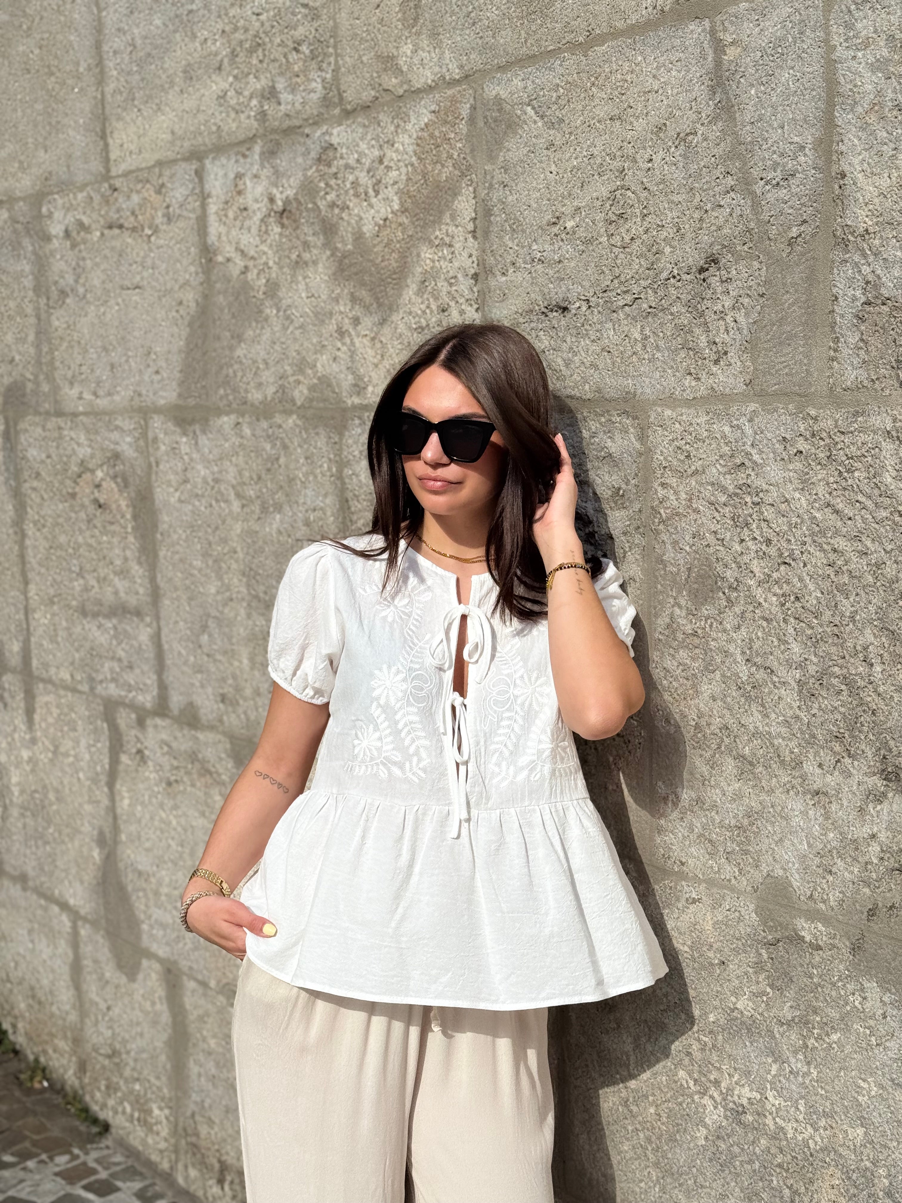 Weiße Bluse mit Stickereien und Bindeband am Ausschnitt