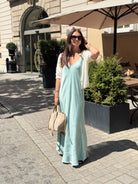 Hannah trägt ein sommerliches Slipkleid in Aqua auf der Straße